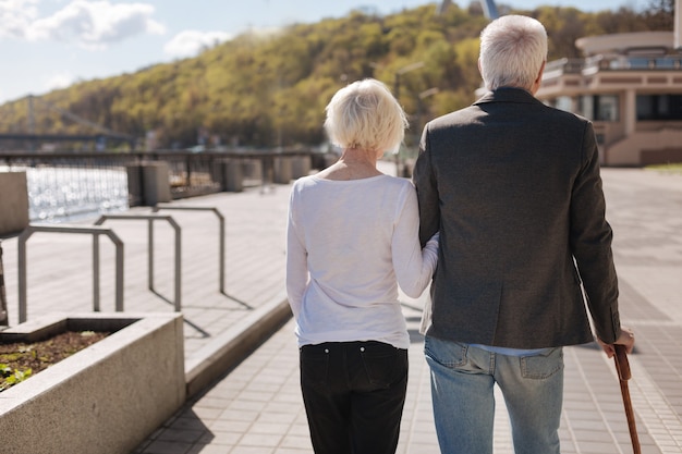 Amable pareja ordinaria de mediana edad descansando juntos mientras van por la carretera y disfrutan del clima