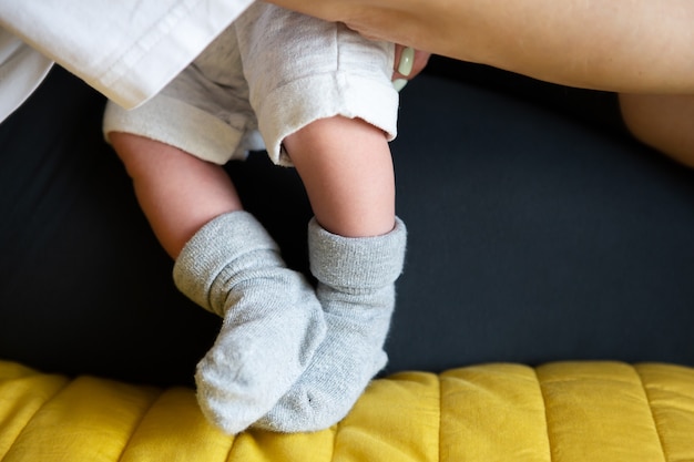 Amamentar com leite materno. Pés pequenos de um bebê recém-nascido em meias. O primeiro mês de vida de um bebê.