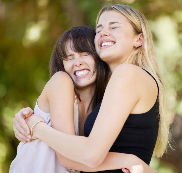 Aman a los amigos y las mujeres abrazan en la naturaleza uniéndose y riendo juntos al aire libre. Apoyan el cuidado de la sonrisa y las niñas felices se abrazan o abrazan por afecto, confianza y amistad en el parque de vacaciones.