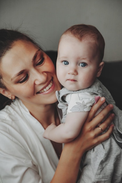 Amando a mãe feliz carregando o bebê recém-nascido em casa