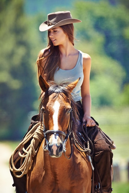 Foto amando el aire libre foto de una hermosa joven montando a caballo