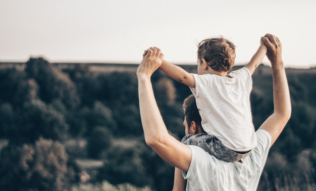 Amando familia. Padre y su hijo bebé jugando y abrazándose al aire libre. Feliz papá e hijo al aire libre. Concepto del día del padre.