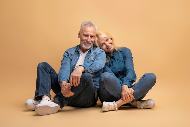 Foto amando a una hermosa pareja de ancianos sentada en el suelo abrazándose