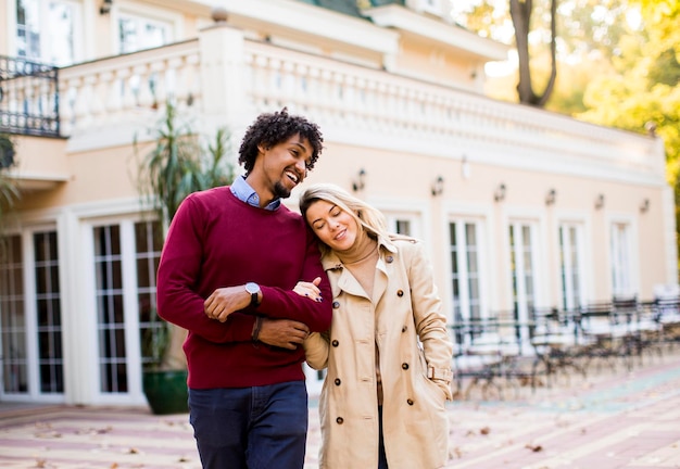 Amando lindo casal homem afro-americano e mulher caucasiana caminhando ao ar livre