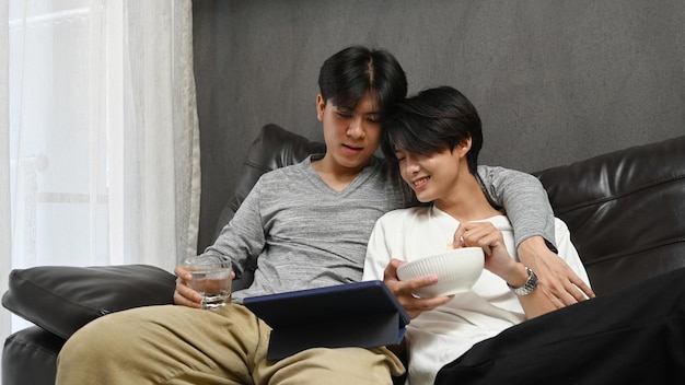 Amando o casal masculino do mesmo sexo abraçando e navegando na internet com tablet digital juntos relacionamentos de orgulho LGBT e conceito de igualdade