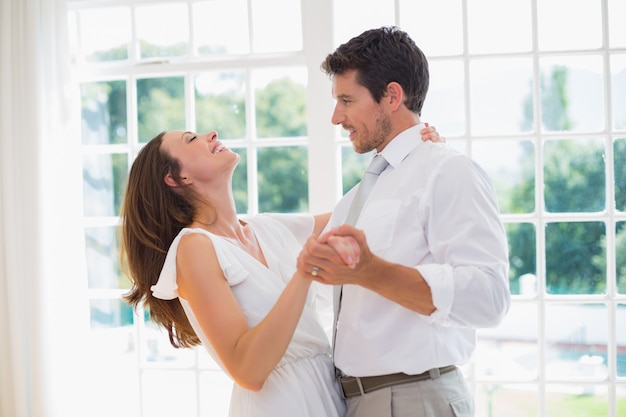 Amando o jovem casal dançando em casa