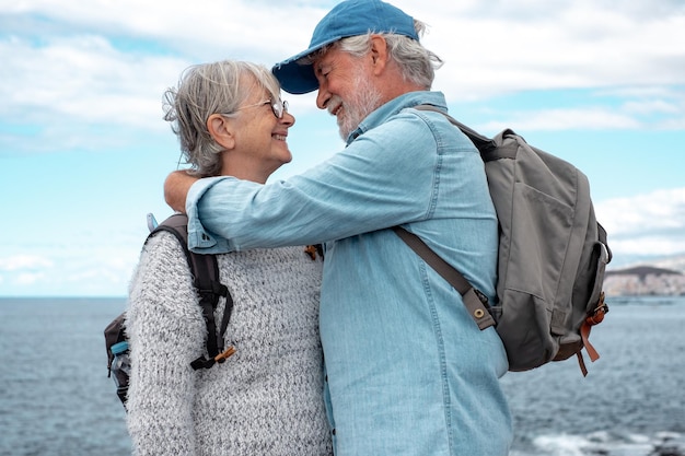 Amando a la vieja pareja de la familia senior bonding abrazándose en el mar romántico anciano y mujer abrazándose