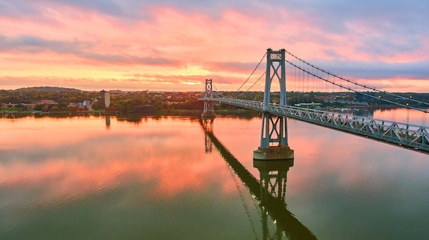 Amanecer aéreo de la hora dorada sobre el impresionante puente estadounidense de Nueva York con luz rosa