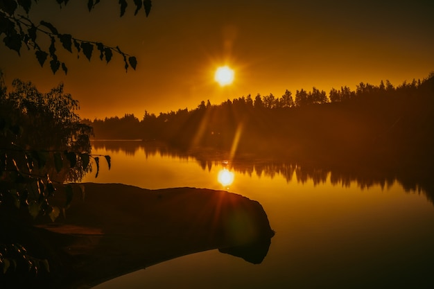 Amanecer amarillo sobre un lago en una cantera inundada, montañas Romance