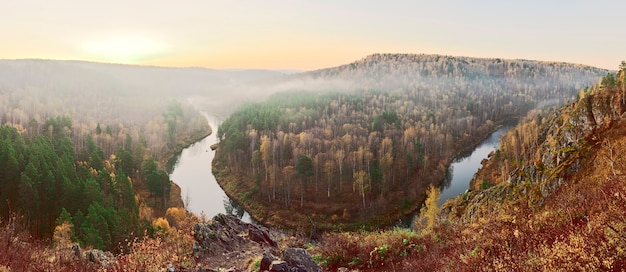 Amanecer brumoso sobre las colinas del contador de la cresta cubierta de bosques de otoño