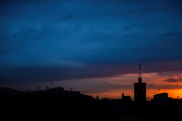 Amanecer con cielo azul, vista superior del techo de una antigua torre de la iglesia.