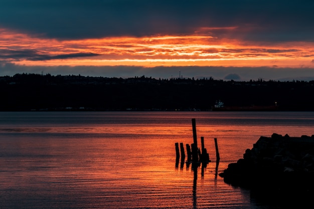 Amanecer dorado en un puerto con un buque de carga