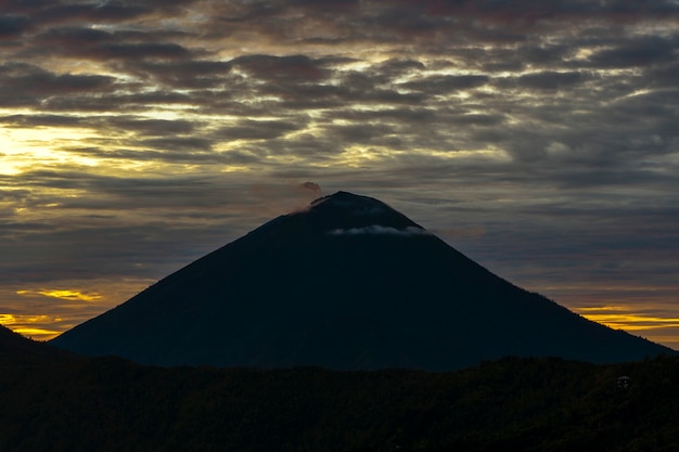 Amanecer escénico en Batur y volcán Agung, Kintamani, isla de Bali, Indonesia. Vista del volcán amanecer desde la cima del monte Agung, paisaje natural. Paisaje nublado con silhoutte de montañas volcánicas