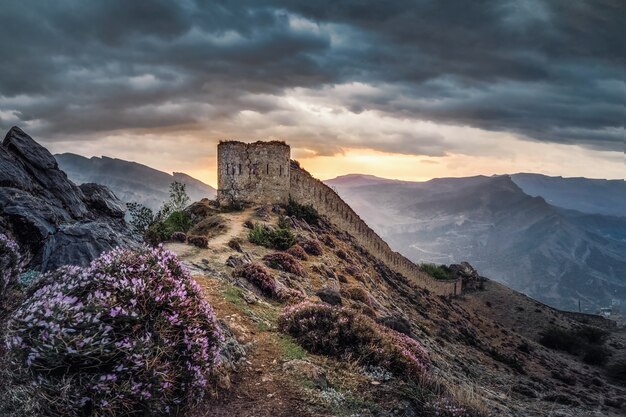 Amanecer espectacular en la antigua fortaleza en la cima de la montaña. La fortaleza de Gunib es un monumento histórico de Daguestán. Rusia.