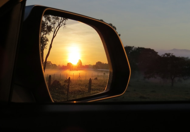 Amanecer en el espejo del coche