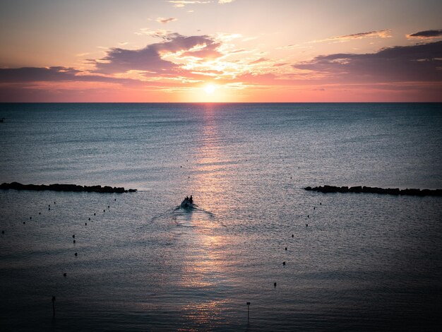 Amanecer en el horizonte con barco de pescadores