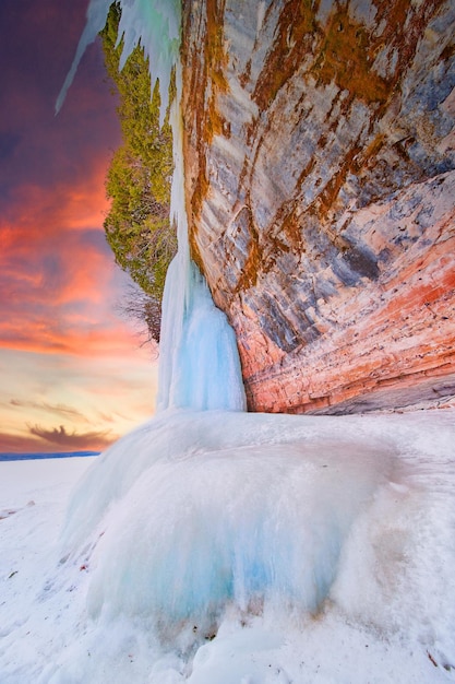 Amanecer de invierno con coloridos acantilados rocosos cubiertos de formaciones de hielo