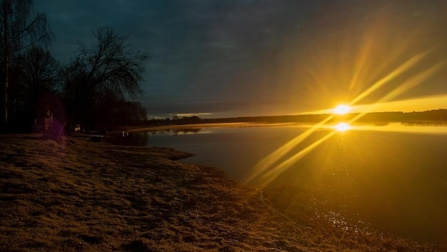 Amanecer junto al río con reflejo en el agua