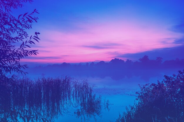El amanecer mágico sobre el lago la niebla de la mañana temprano el lago de la serenidad