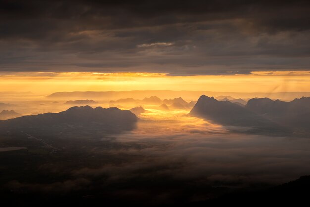 Amanecer de la mañana con la niebla en las montañas