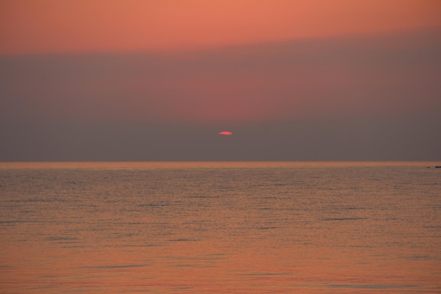 Amanecer del mar rojo desde el mar en verano