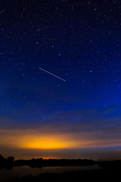 Amanecer matutino en un cielo estrellado de fondo reflejado en el agua del lago