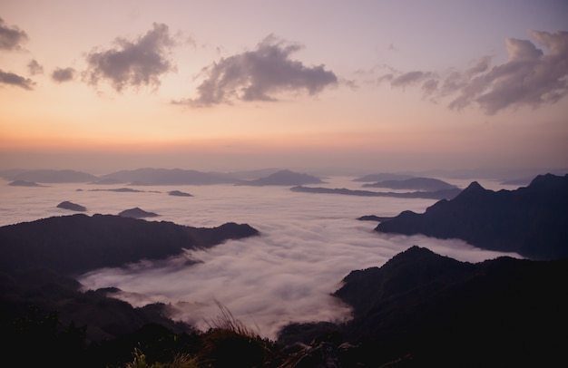 Amanecer con montaña oscura y niebla