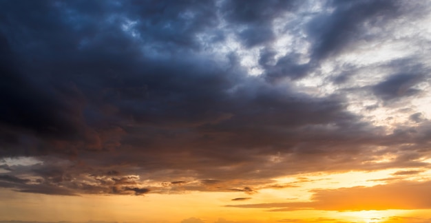 Amanecer natural al atardecer. Cielo dramático brillante y suelo oscuro. Paisaje de campo bajo el pintoresco cielo colorido