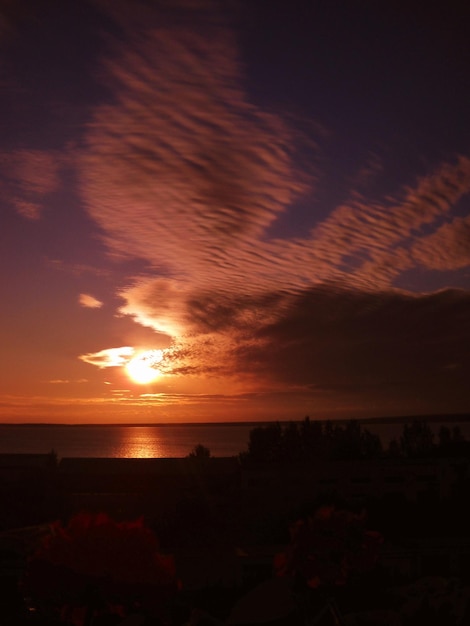 Amanecer en el norte Mañana de verano con un amanecer sobre el lago Onega Karelia Un sol amarillo se eleva sobre el horizonte El cielo es marrón y amarillo naranja Nubes estratocúmulos Puesta de sol en el lago