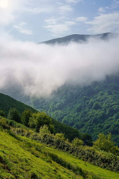 Amanecer entre las nubes de las montañas en un paisaje verde