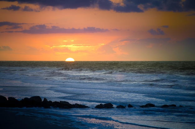 Amanecer en la playa de Folly con cielo naranja en Carolina del Sur