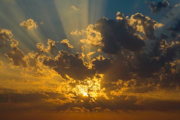 Amanecer con rayos de sol radiales atravesando las nubes