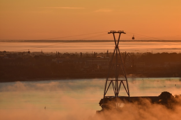 amanecer sobre el teleférico que cruza el río