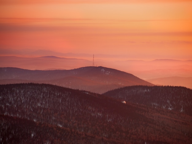 Amanhecer carmesim sobre as colinas na região de Kemerovo. Cores brilhantes do nascer ou pôr do sol nas montanhas.