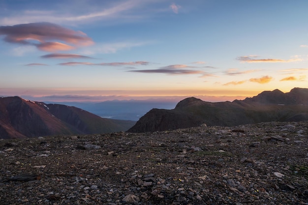 Amanhecer nas montanhas. cenário colorido da natureza com pôr do sol ou nascer do sol. paisagem atmosférica com silhuetas de montanhas com árvores no fundo do céu laranja amanhecer.