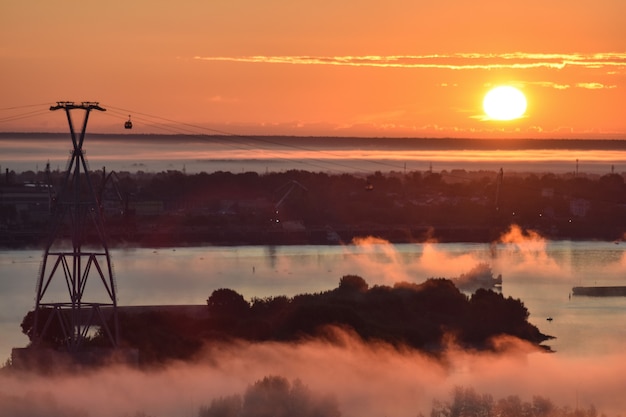 Amanhecer sobre o teleférico do outro lado do rio