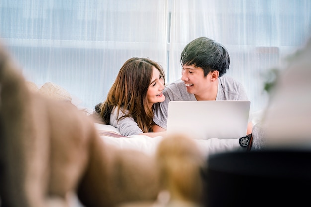 Amante feliz closeup asiáticos ou casal usando laptop tecnologia para preparar e reservar a viagem tri