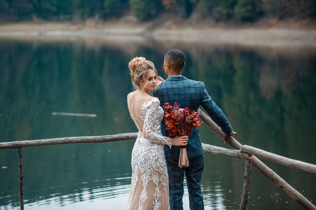 Amante hombre y mujer en el día del matrimonio en el hermoso lago