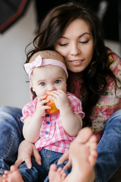 Amante de la joven madre riendo abrazando sonriendo lindo divertido niño hija disfrutando de tiempo juntos en casa