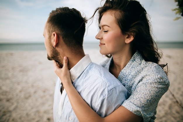 Amante joven pareja abrazándose y besándose en la playa del mar. Concepto de amor