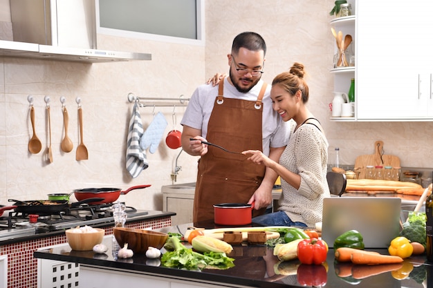 Amante joven pareja asiática cocinando en la cocina haciendo comida sana juntos sintiéndose divertido