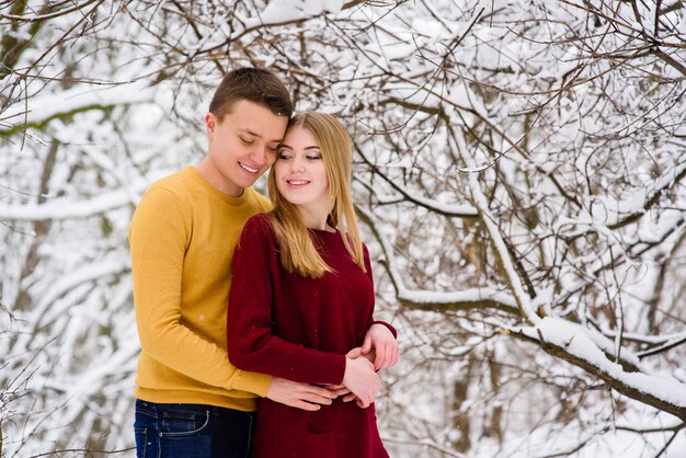 Amante joven pareja en el bosque de invierno