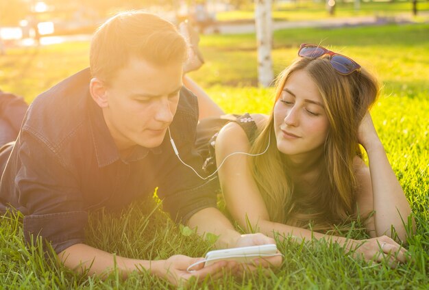 Amante de la joven pareja en el parque de verano escuchando música.