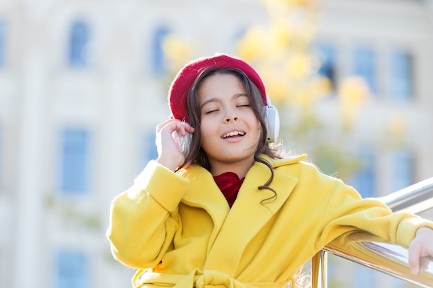 Amante de la música inspirada niña escucha audiolibro niña en auriculares educación en línea