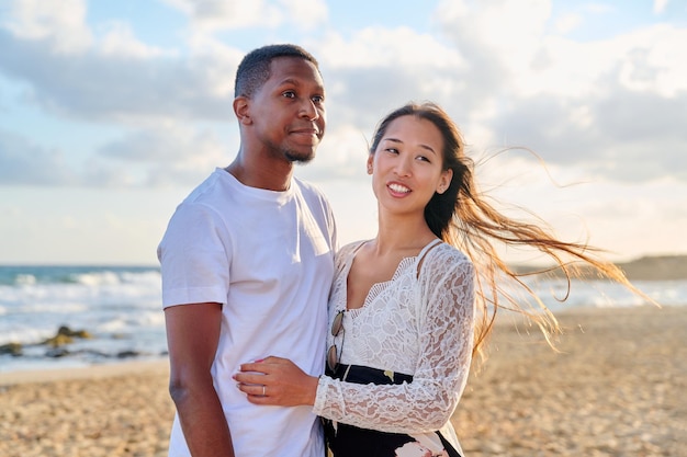 Amante romántico abrazando a una pareja joven en la orilla del mar