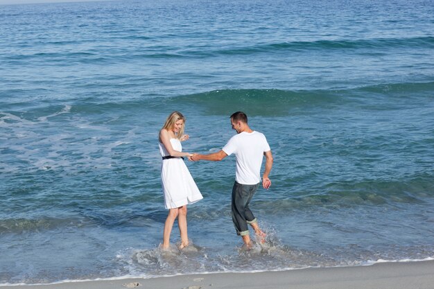 Amantes alegres que se divierten en la playa