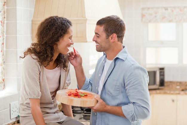 Amantes comendo um morango na cozinha