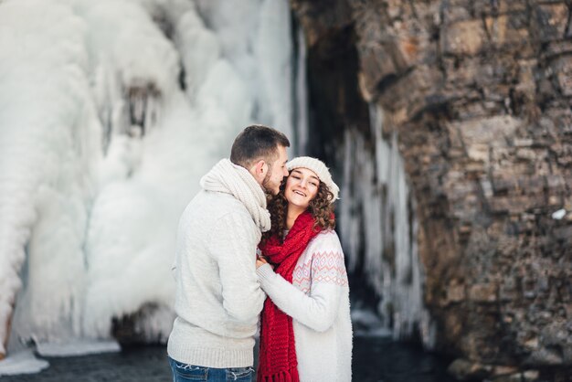 amantes en invierno en la cascada a pasear