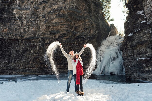 amantes en invierno en la cascada a pasear