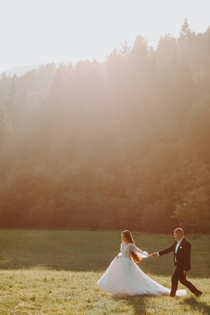 Amantes novios besándose en las montañas al atardecer. retrato, de, novia y novio